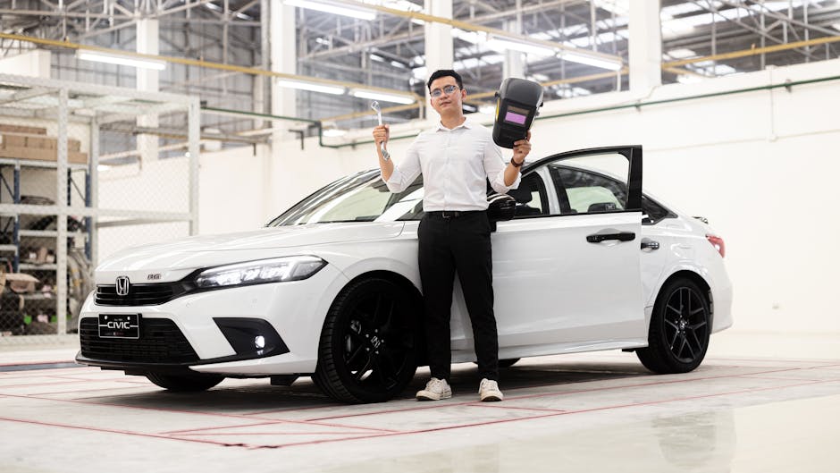 Man holding tools near a Honda Civic in a Phnom Penh automotive workshop.